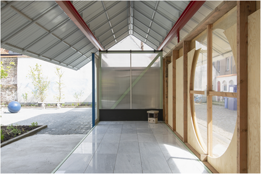 A partially open pavilion interior, featuring a mix of used elements and materials.