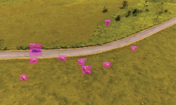 An aerial photo of a grassy field with a road winding through it.