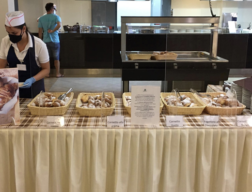 Photograph of experimental set-up with treatment message at the croissant buffet Refer to the image caption for details.