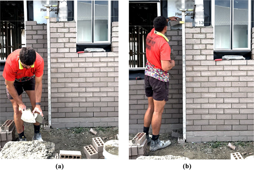 A bricklayer mixes and applies mortar while constructing a wall beneath a house window.