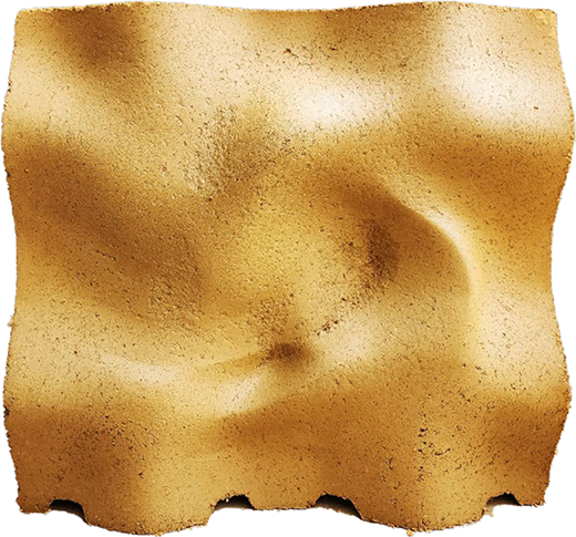 A rammed earth block with an undulating surface and compact texture.