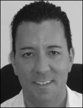 A portrait that presents a man with short dark hair shown above printed contact information.