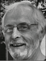 A smiling older man with glasses and a beard is shown in black and white. The background is blurred, conveying a warm and cheerful tone.