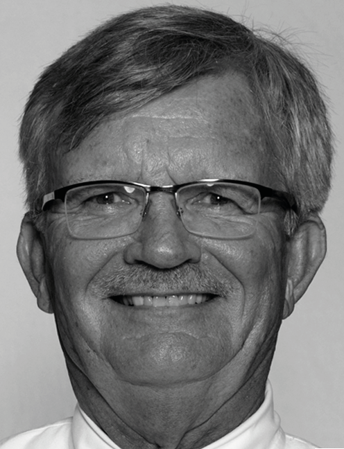 Man wearing glasses, collared shirt smiles for headshot. Labelled, Michael Simonson, Editor, Distance Learning, and Program Professor.