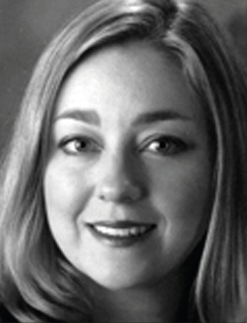 Smiling woman with long hair faces forward, plain dark background. Labelled, Barbara Zorn-Arnold, Ashford University.