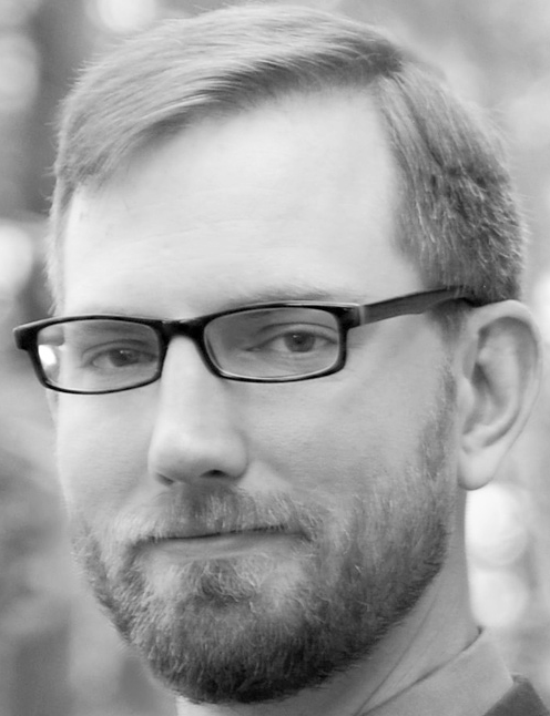 Man with short beard and glasses looks forward in a black and white headshot. Labelled, Jeffrey Wessmiller, Training Specialist.