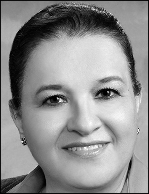 A black and white portrait of Patricia C Abrego smiling.