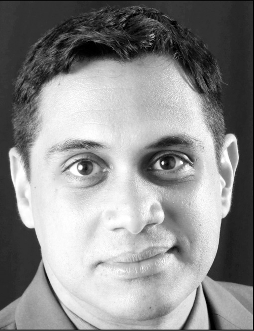A black and white photograph of a man with contact information.