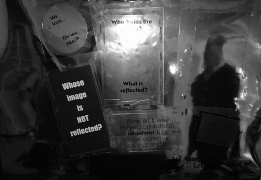 A grayscale illustration showing several translucent cards arranged together, each displaying text such as Whose image is not reflected, Who holds the mirror, What is reflected, and We look dot dot dot Do we see.