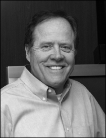 A headshot of Michael Baker, Chair Emeritus slash Board Member of U S D L A and Vice President of VBrick Systems, with his contact information.