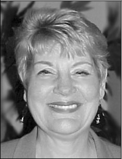 Sandra Ratcliff Daffron, black-and-white photo of smiling woman with short light hair and earrings, with text showing.