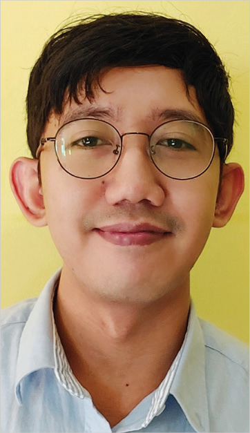 Nanak Hikmatullah with glasses, short dark hair, light blue shirt.