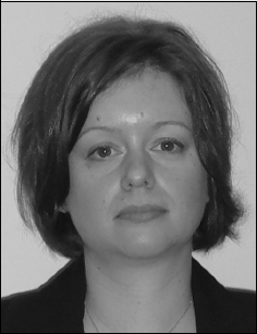 A black and white photo of a woman with short hair, gazing thoughtfully into the distance.