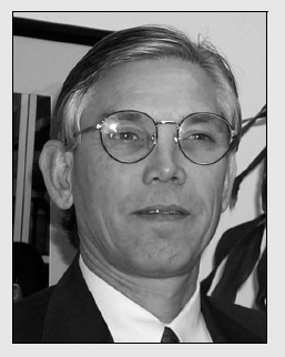 A black and white portrait of a bespectacled man, his gaze directed away from the camera.