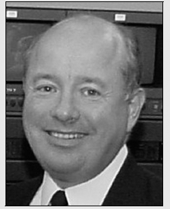 Black and white portrait of a man in a suit and tie, showcasing a formal and sophisticated appearance.