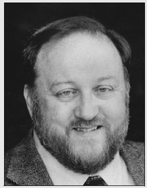 Black and white portrait of a man with a beard, focusing on his expression and features.