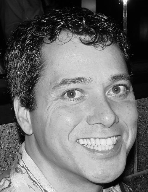 A grayscale portrait of a man above printed text listing his name, teaching role, school affiliation, mailing address, telephone number, and email.