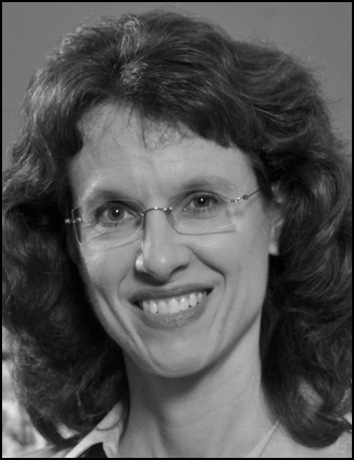 Portrait of a woman Cathy Cavanaugh with curly hair and glasses smiling; below the photo is printed contact information for an associate professor at a university.