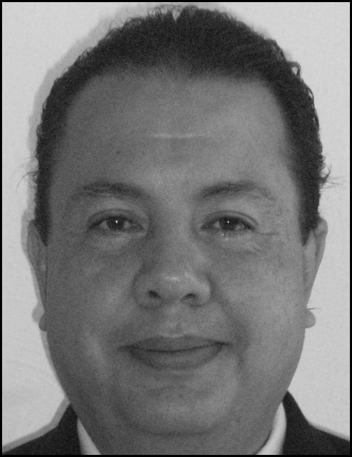 A grayscale portrait of an adult person appears above a block of printed professional information that lists an academic title, institutional affiliation, physical address, telephone number, and email.