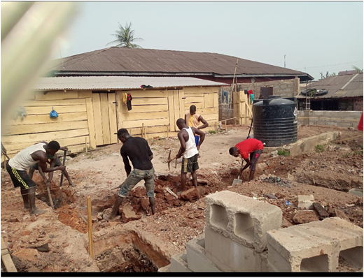 A photograph of workers digging foundation trenches at a construction site.