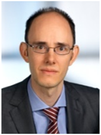 A photograph of Edward W.N. Bernroider, a balding man in a suit and glasses, looking at the camera with a neutral expression.