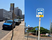 Two roadside transit signs stand along urban pavements beside parked vehicles and city streets.