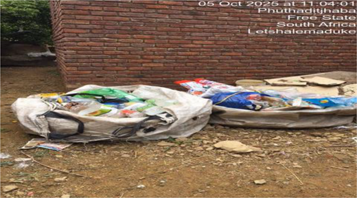 Two large open sacks filled with discarded containers and packaging rest on bare ground beside a brick wall, with location and timestamp text above.