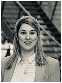 A woman with long hair wearing a blazer and striped shirt.