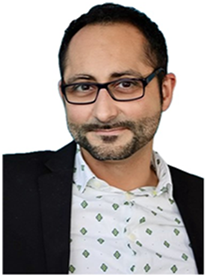 A man wearing glasses and a patterned shirt.