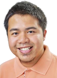 A head shot of a male in an orange collared shirt, facing forward and smiling.