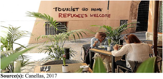 A photograph shows café diners beneath graffiti reading “TOURIST GO HOME REFUGEES WELCOME”.