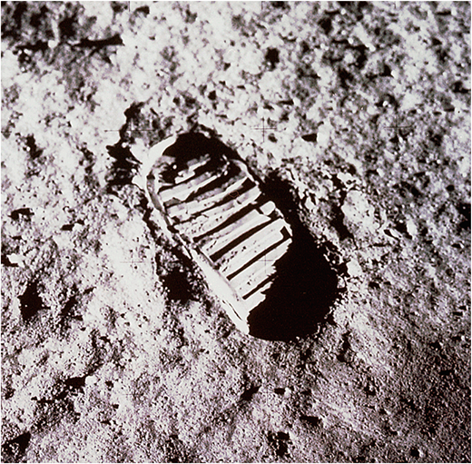 A photograph shows a single boot footprint pressed into a rough ground surface.