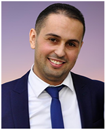 A man in a suit and tie smiling.