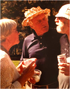 Three people standing outdoors, engaged in conversation.