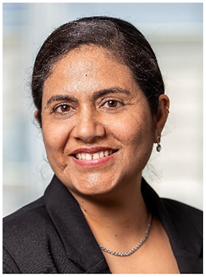 A photograph of Ravdeep Kour smiling while looking at the camera.