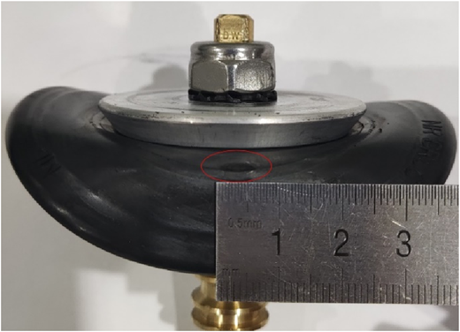 A side view of a compact mechanical assembly featuring a round, air-filled rubber component.
