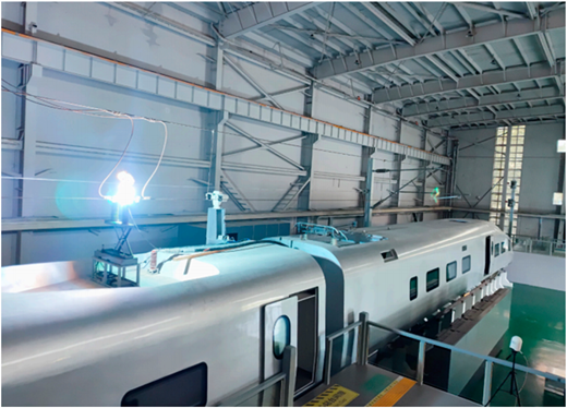 A train inside a large industrial building with overhead lighting.